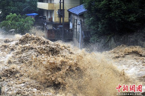 6月14日，福建南平西芹镇，山洪肆虐，涌向民房。这二日延平区降特大暴雨,强降雨导致延平、顺昌等地多处出现山体滑坡、泥石流等地质灾害。中新社发 柳涛 摄